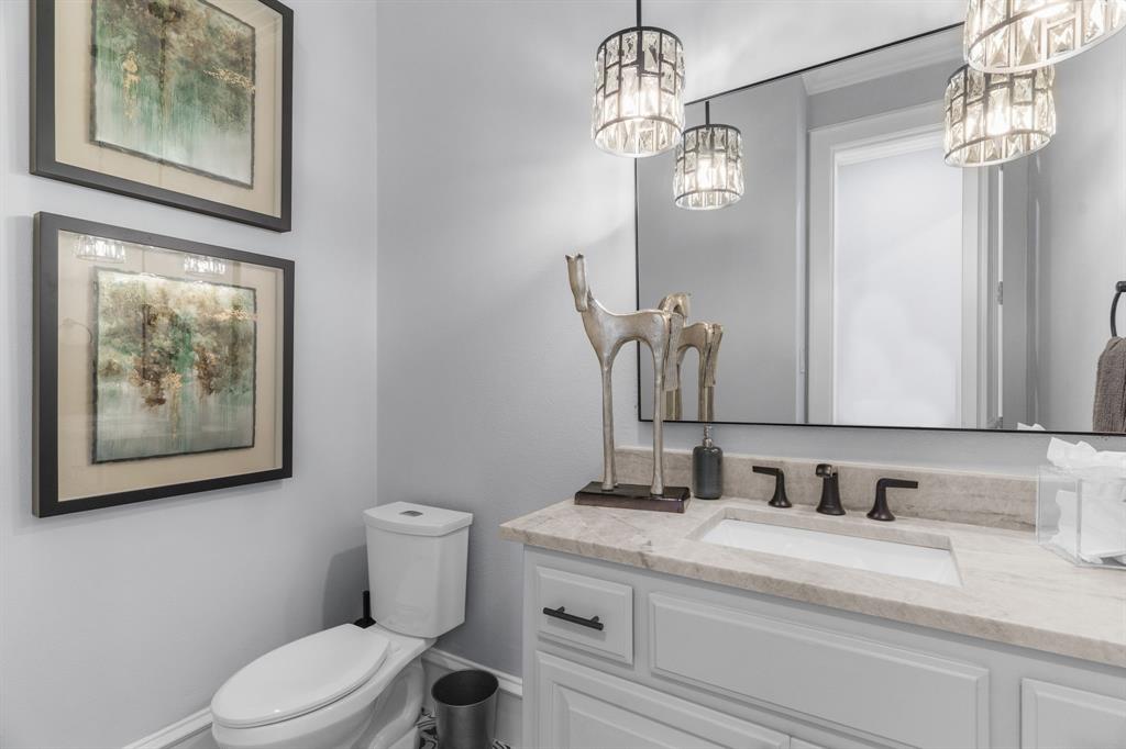 2222 Worthington Street Dallas, TX 75204 - Photo 16 of 39 a bathroom with a granite countertop sink a toilet and a mirror