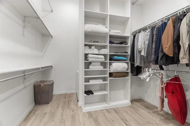 a view of walk in closet with clothes and shoes