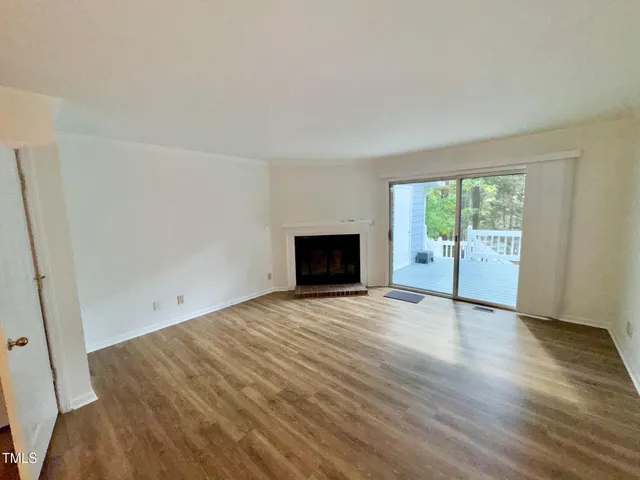 an empty room with wooden floor and a window