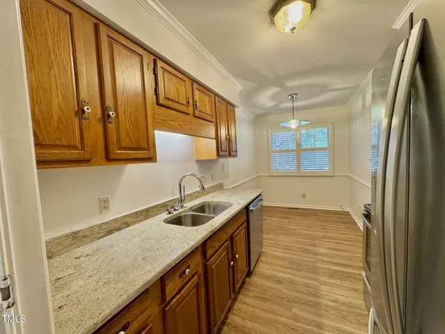 a kitchen with stainless steel appliances granite countertop a sink and a refrigerator