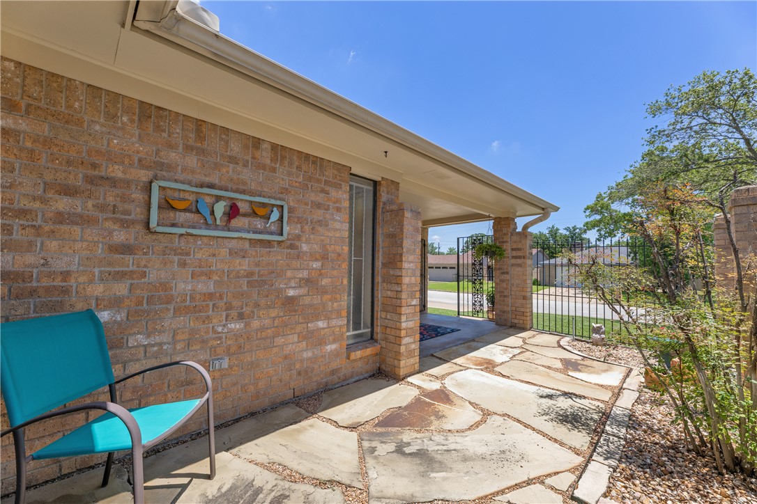 2911 Braeburn Street Bryan, TX 77802 - Photo 6 of 30 Brick exterior featuring a covered entryway with flagstone paving and wrought iron gate.