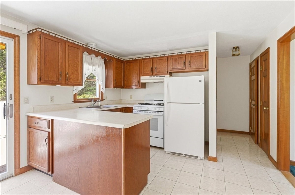 46 Willow Ridge Drive, Unit 46 Bridgewater, MA 02324 - Photo 11 of 40 a kitchen with a refrigerator sink stove and cabinets