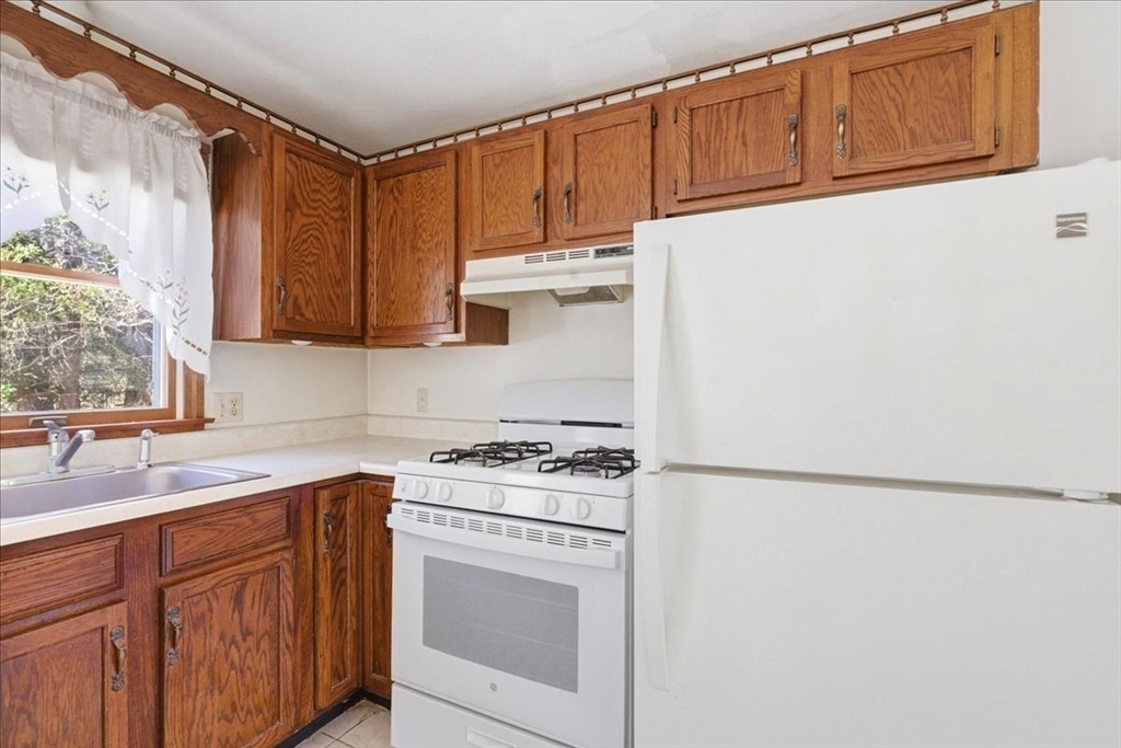 46 Willow Ridge Drive, Unit 46 Bridgewater, MA 02324 - Photo 19 of 40 a kitchen with stainless steel appliances granite countertop a sink stove and refrigerator