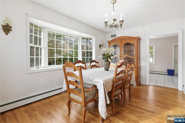 a view of a dining room with furniture a chandelier and wooden floor