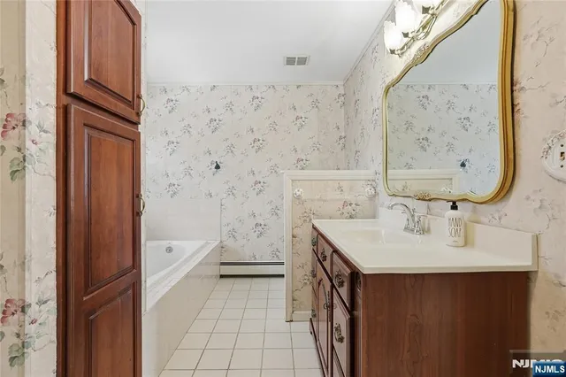a view of a hallway with closet and a bathroom