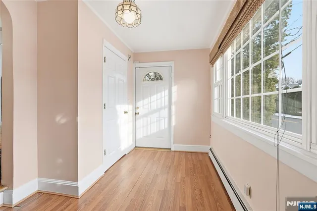 a view of a hallway with wooden floor and a window