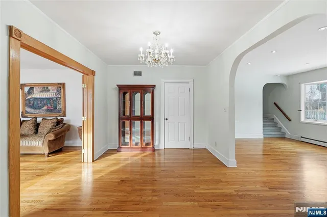 a view of a livingroom with wooden floor and a chandelier