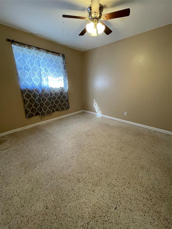 5738 Lincoln Street, Unit B Hollywood, FL 33021 - Photo 4 of 25 an empty room with a chandelier fan and a fireplace