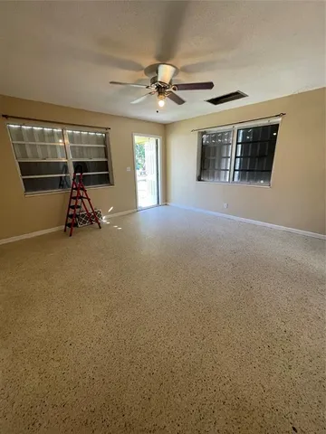 a view of a livingroom with a ceiling fan and window