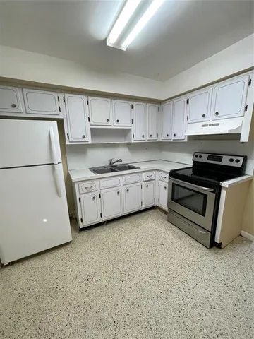 a kitchen with white cabinets and white appliances