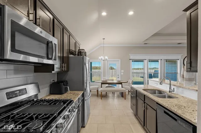 a kitchen with stainless steel appliances granite countertop a refrigerator and a sink
