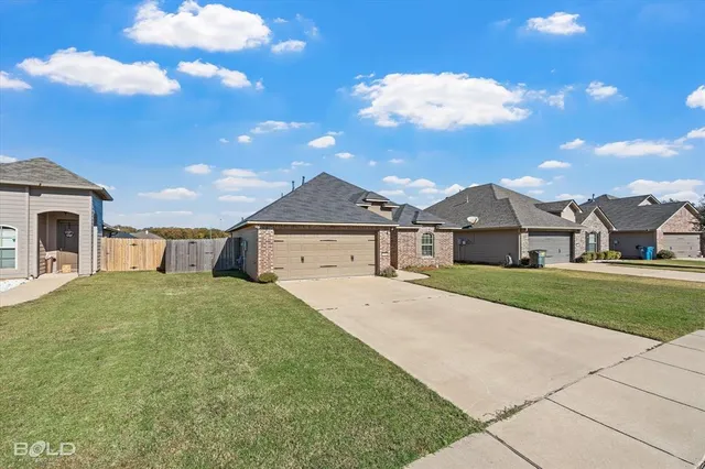 a view of a yard in front of a house with large trees