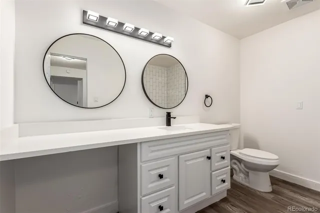 a bathroom with a toilet a sink and a mirror
