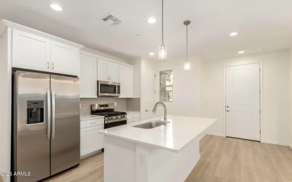 a kitchen with stainless steel appliances a refrigerator sink and microwave