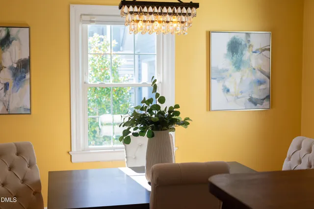 a dining room with furniture a chandelier and wooden floor
