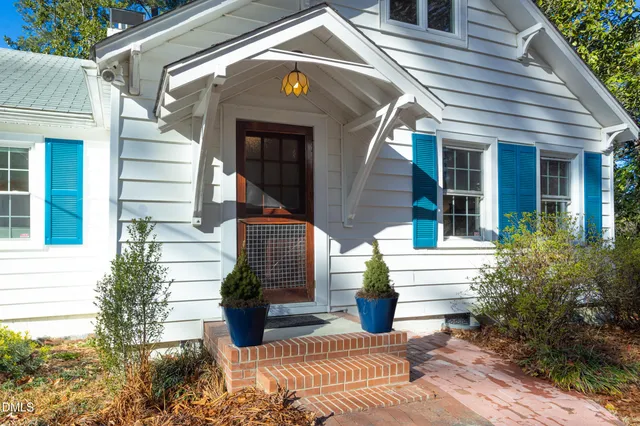 a front view of a house with potted plants