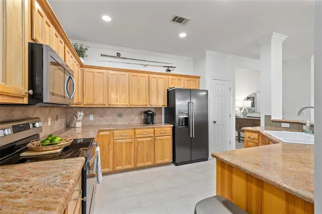 a kitchen with stainless steel appliances granite countertop a sink a stove and a refrigerator