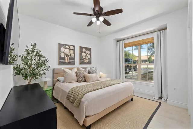 a bedroom with a bed a chandelier and a window
