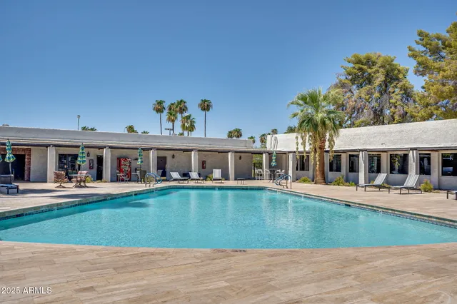 a front view of a house with swimming pool having outdoor seating
