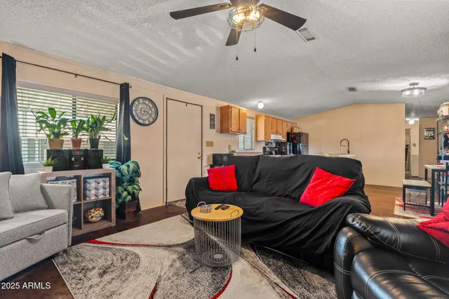 a living room with rug floor and a chandelier