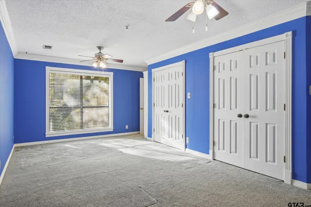 a room with a cabinet and a ceiling fan