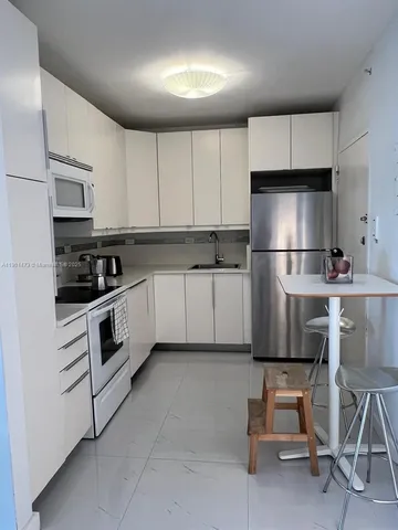 a kitchen with cabinets stainless steel appliances and a sink