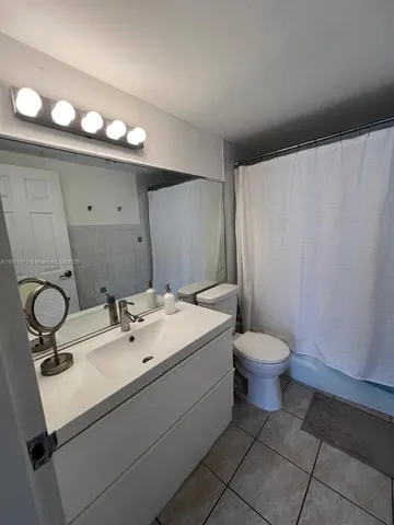 a bathroom with a sink a toilet and mirror