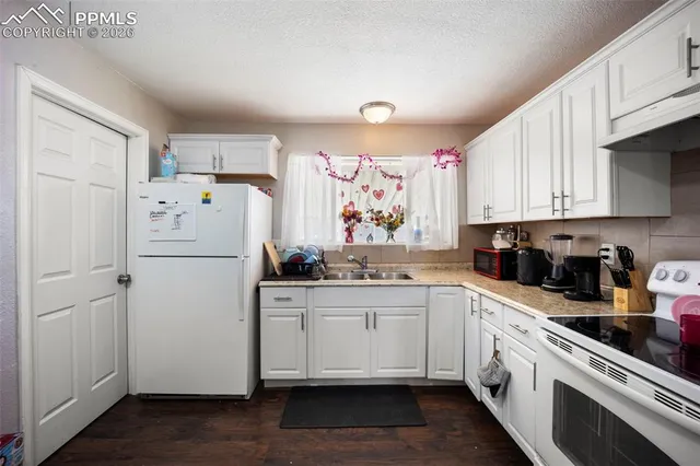 a kitchen with white cabinets and white appliances