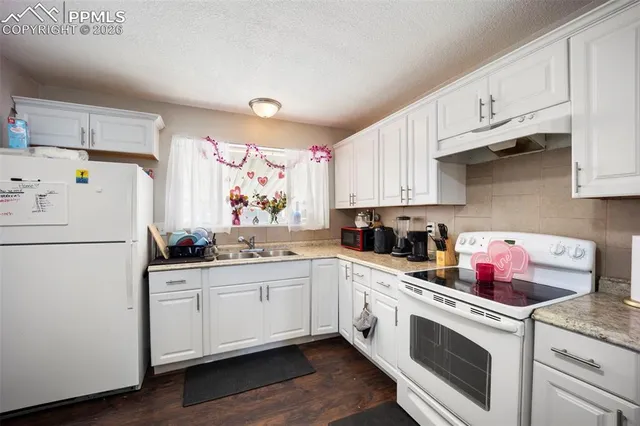 a kitchen with white cabinets sink and white appliances