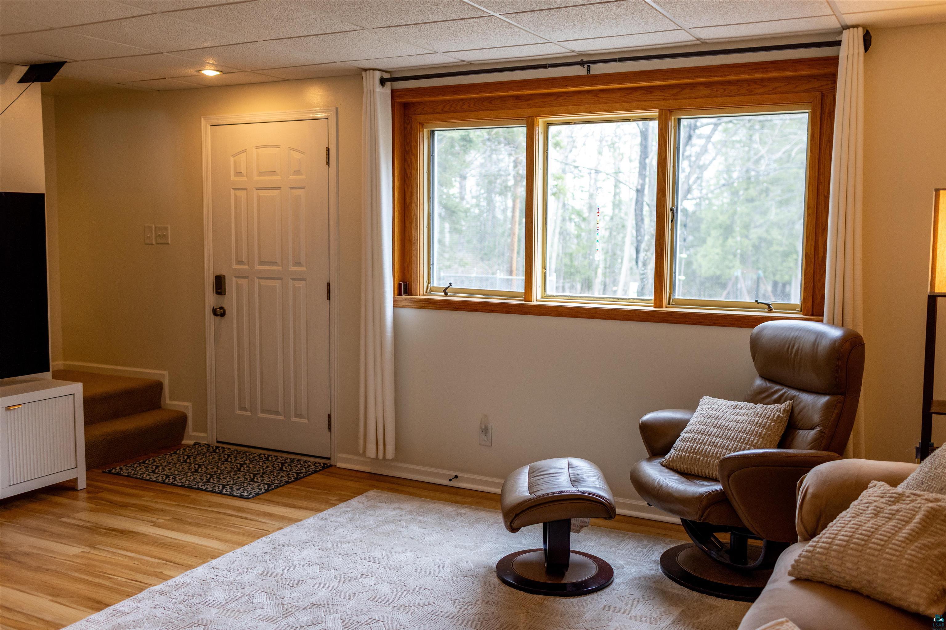 3704 Greysolon Road Duluth, MN 55804 - Photo 25 of 51 Bright room featuring natural wood window trim, a paneled door, wood-finish flooring, recessed lighting, and a textured drop ceiling