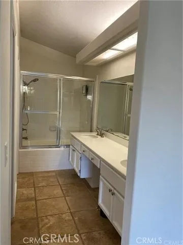a bathroom with a granite countertop sink a mirror and a bathtub