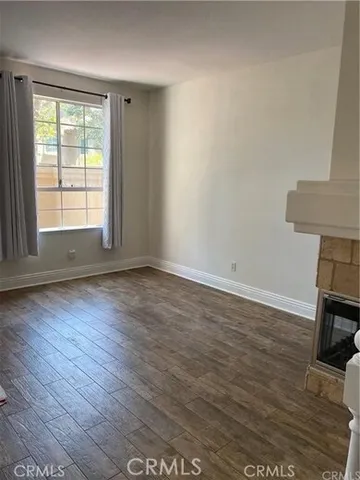 an empty room with wooden floor and a window