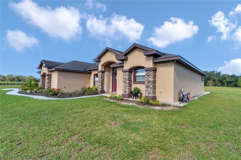 1671 West Highway 316 Citra, FL 32113 - Photo 34 of 46 a front view of a house with a yard and garage