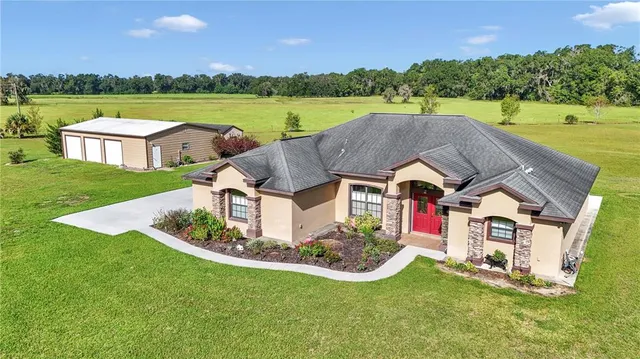 an aerial view of a house with swimming pool garden and outdoor seating