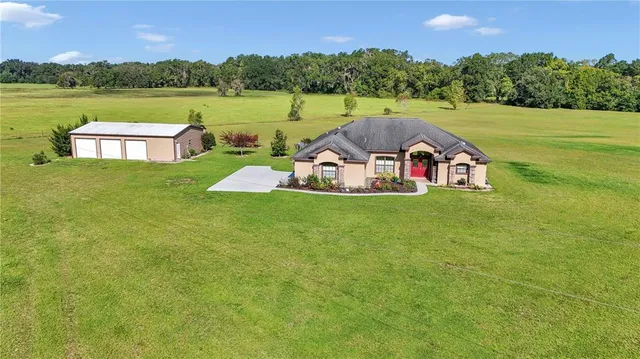 a view of a lake with a yard and large trees