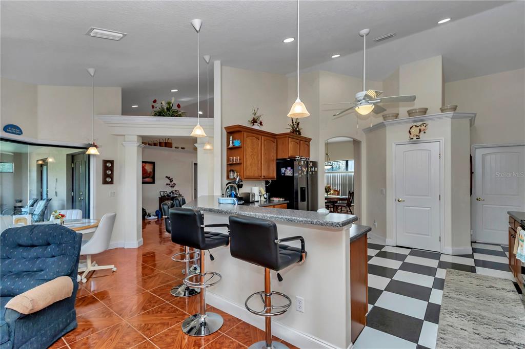 1671 West Highway 316 Citra, FL 32113 - Photo 8 of 46 a kitchen with stainless steel appliances kitchen island granite countertop a refrigerator a stove a sink and a dining table with wooden floor