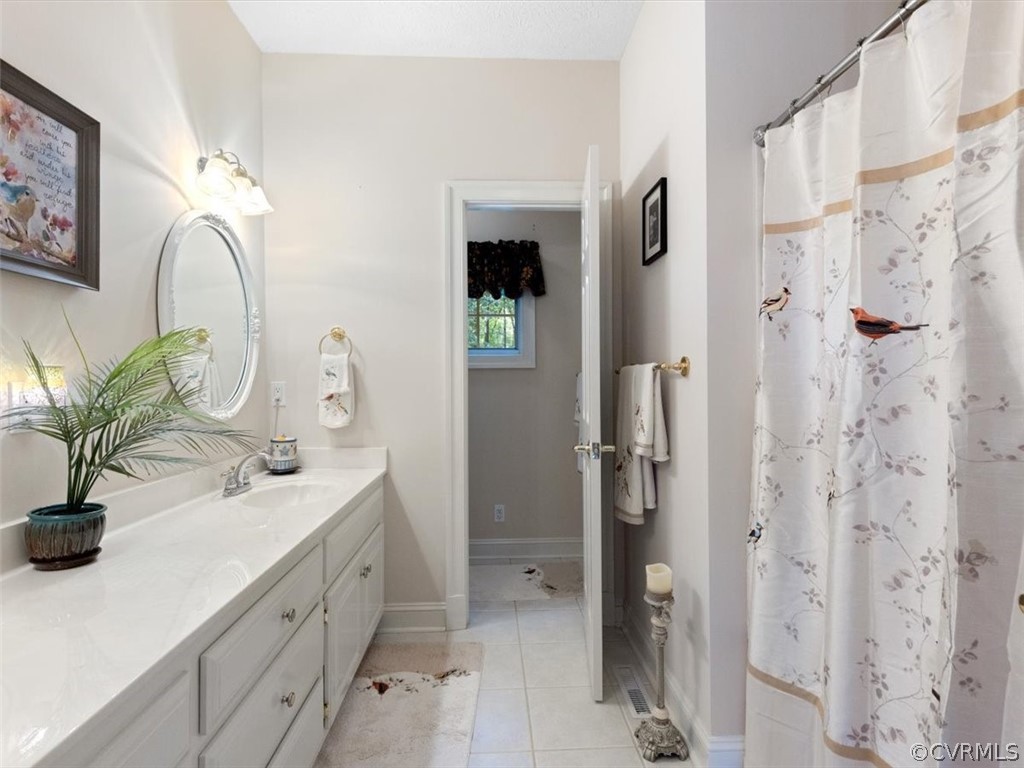 13030 River Road Chesterfield, VA 23838 - Photo 34 of 50 a bathroom with a double vanity sink a mirror and shower