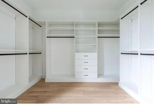 a view of walk in closet with empty racks