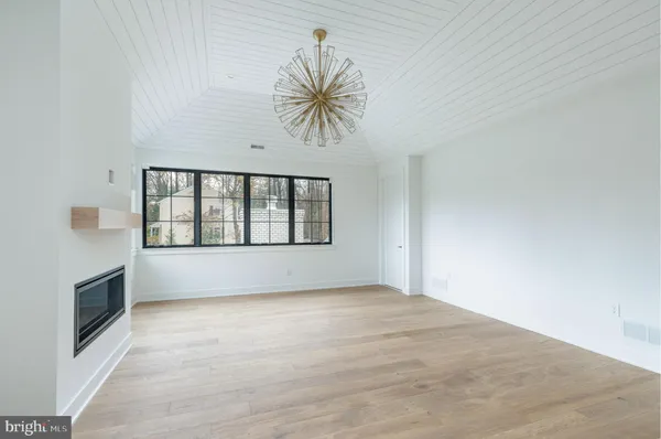 a view of an empty room with a window and fireplace