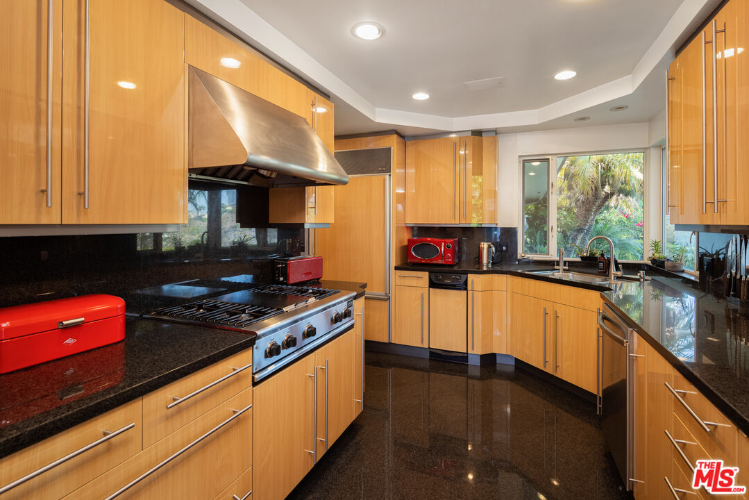 1000 Stradella Road Los Angeles, CA 90077 - Photo 17 of 45 a kitchen with stainless steel appliances granite countertop a stove a sink and a microwave