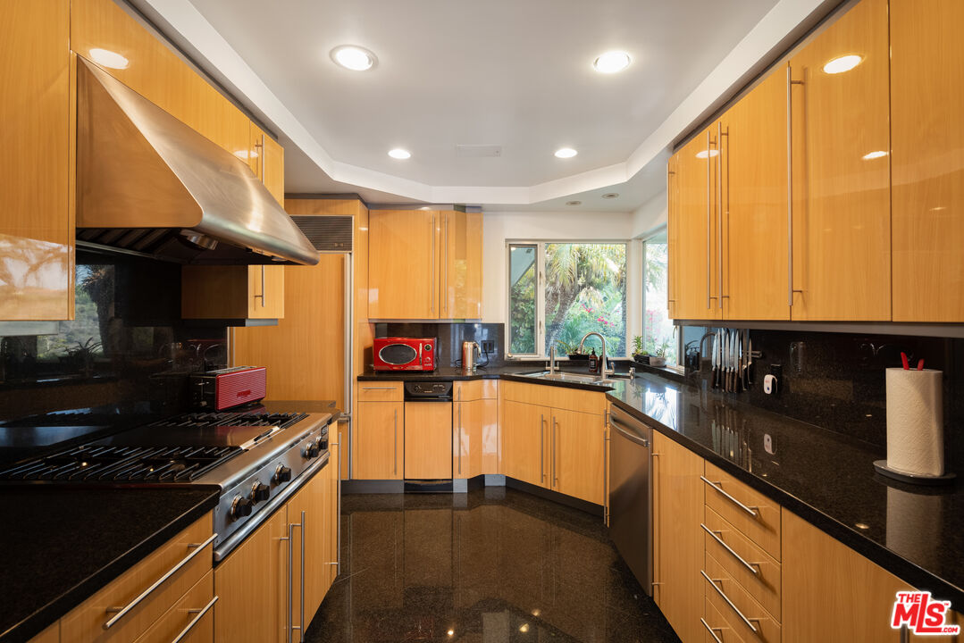 1000 Stradella Road Los Angeles, CA 90077 - Photo 18 of 45 a kitchen with stainless steel appliances a sink stove and cabinets