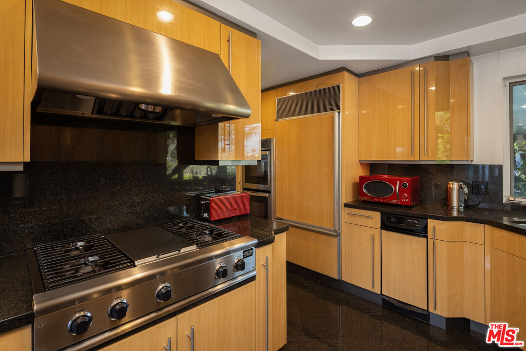 1000 Stradella Road Los Angeles, CA 90077 - Photo 19 of 45 a kitchen with stainless steel appliances granite countertop a stove and a refrigerator