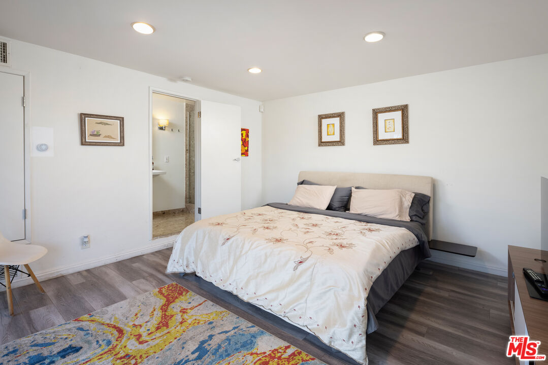 1000 Stradella Road Los Angeles, CA 90077 - Photo 3 of 45 a spacious bedroom with a bed and a painting on the wall