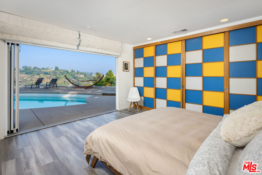 1000 Stradella Road Los Angeles, CA 90077 - Photo 7 of 45 a bedroom with a bed and a painting on the wall