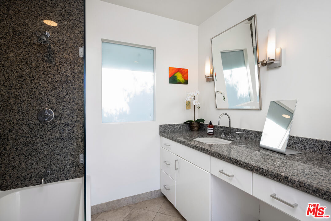 1000 Stradella Road Los Angeles, CA 90077 - Photo 9 of 45 a bathroom with a granite countertop sink and a mirror