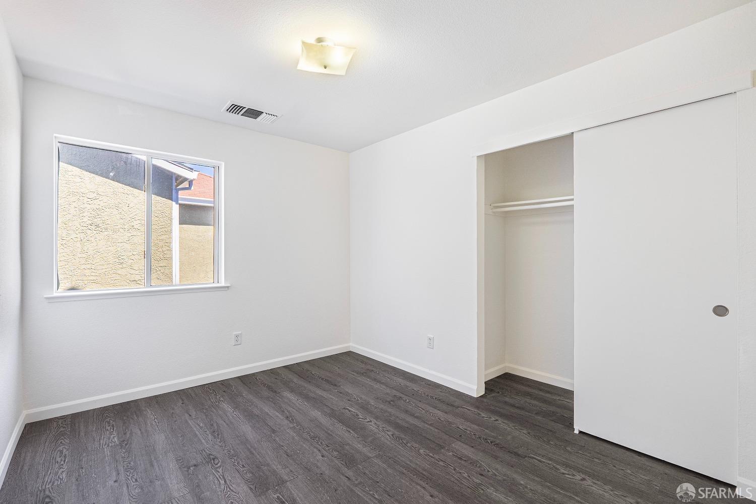 117 Malcolm Drive Richmond, CA 94801 - Photo 24 of 37 an empty room with wooden floor and windows