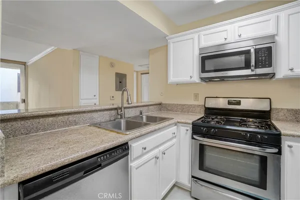 a kitchen with stainless steel appliances granite countertop a sink stove and microwave