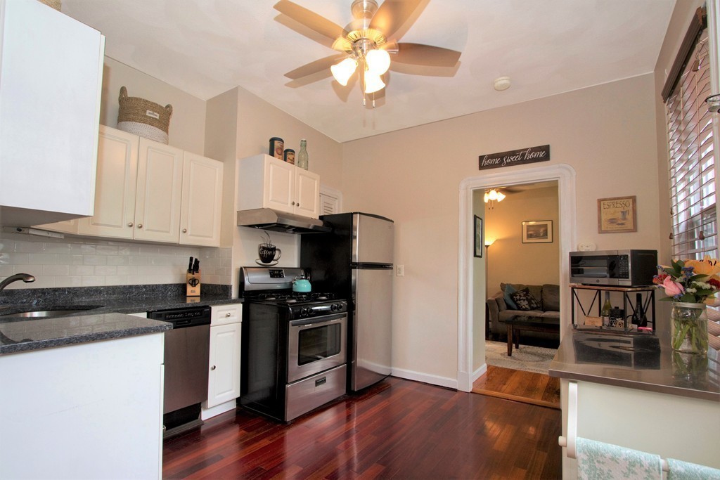 25 Sullivan Street, Unit 3 Boston, MA 02129 - Photo 6 of 13 a kitchen with granite countertop a stove top oven a sink a counter space and cabinets