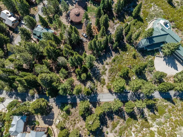 an aerial view of residential house with outdoor space and trees all around