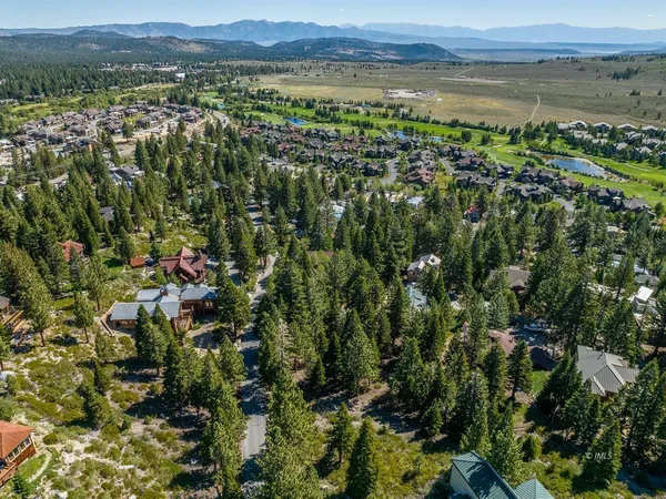 a view of a lush green field with lots of buildings in the background
